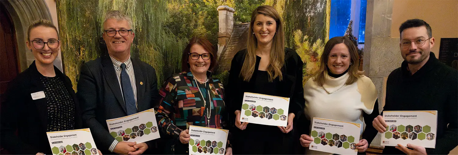 A group of people at the stakeholder engagement plan launch holding the new report