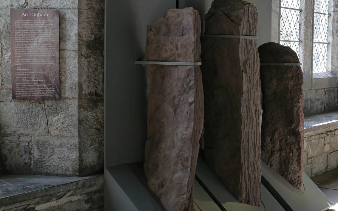 A carved stone in front of a window in UCC's North Wing building